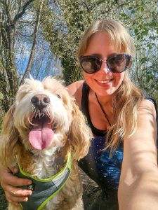 An adorable golden cockapoo looks delighted as he poses for a selfie with his dog walker, Steph, on a very sunny day in Cambridge.